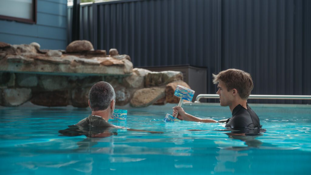 Hydrotherapy pool in woodford, crystal clear water with exercise physiologist and client swimming in the pool